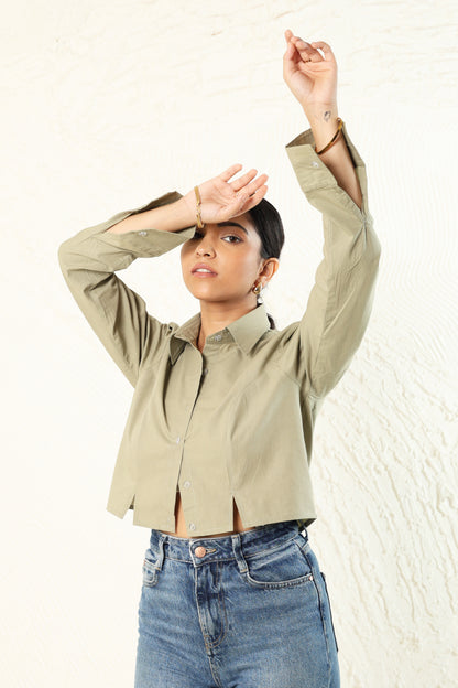 Person wearing a beige jacket and blue jeans against a white background