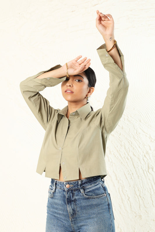 Person wearing a beige jacket and blue jeans against a white background