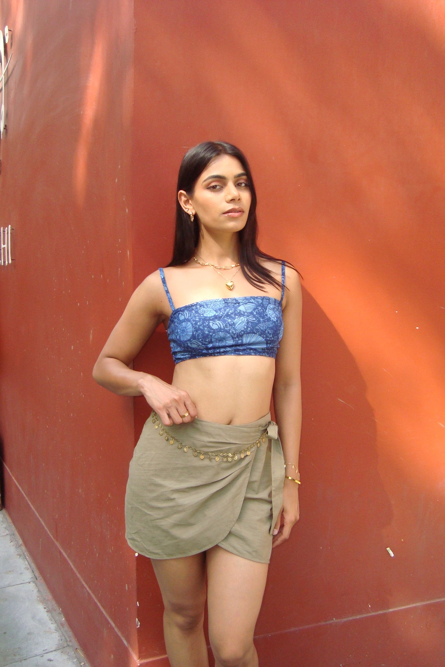 Woman wearing a blue top and green skirt.