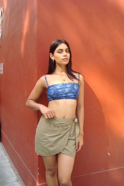 Woman wearing a blue top and green skirt.