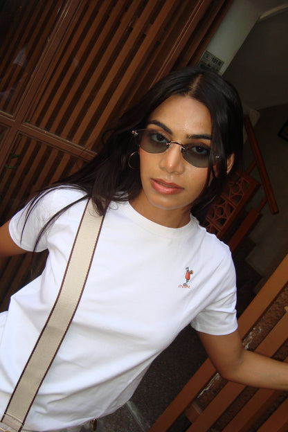 Woman wearing sunglasses and a white t-shirt.