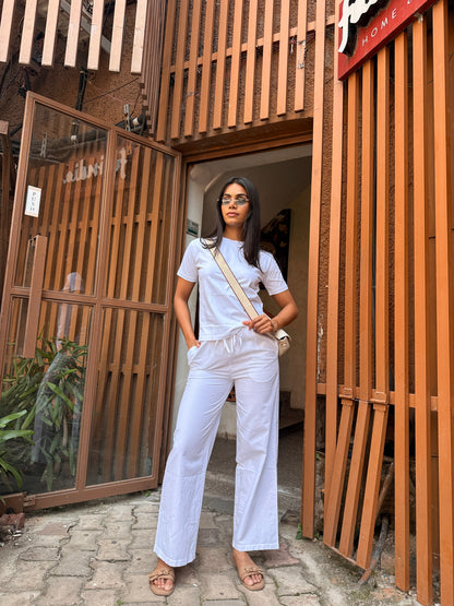 Person holding a white garment in front of a wooden door
